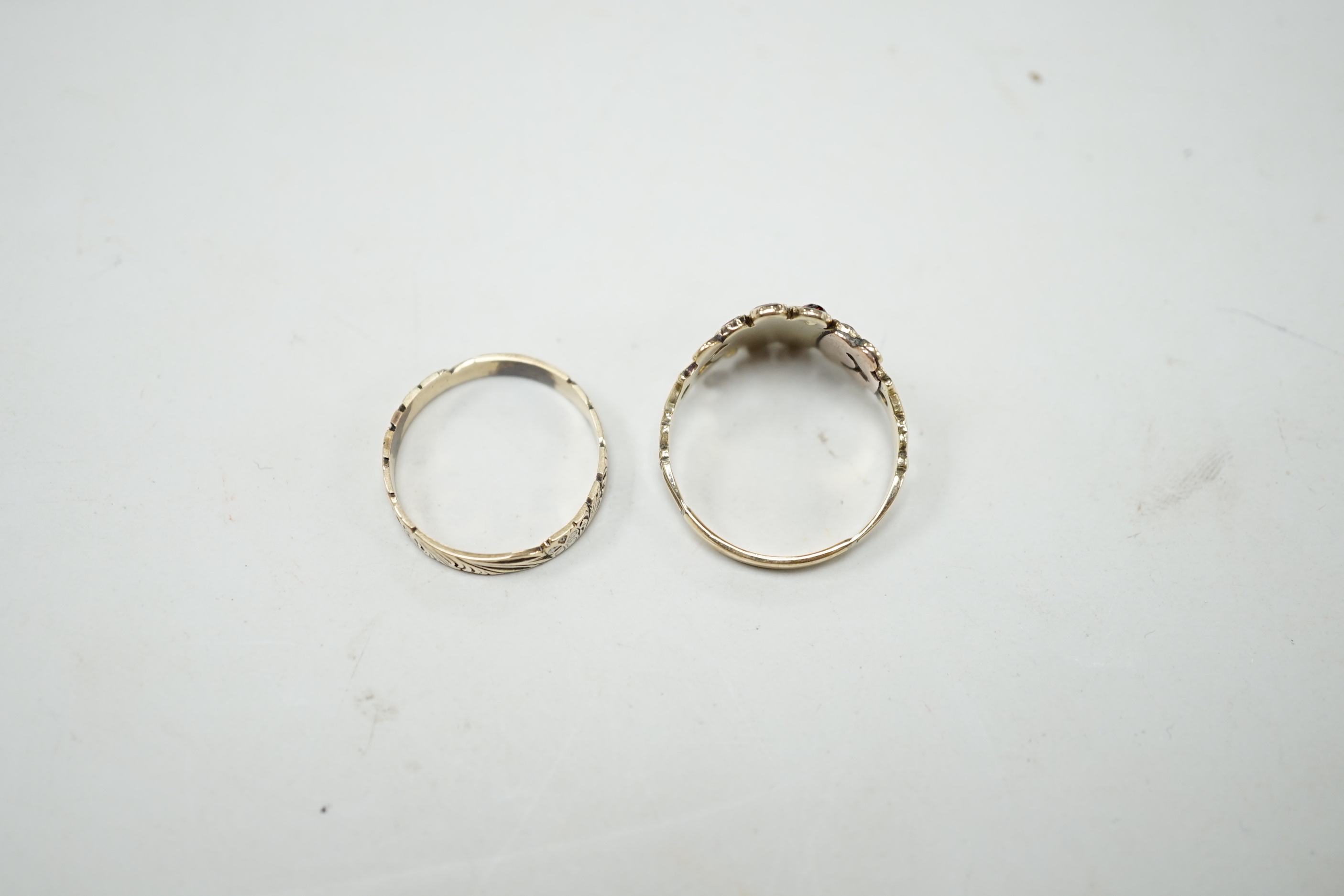 An early 19th century yellow metal, garnet and seed pearl cluster set ring, size P and a 19th century yellow metal and two colour enamel set band.